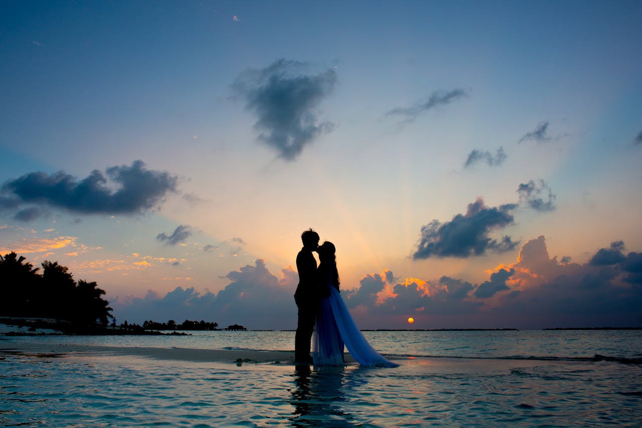 Novios en la playa bajo la puesta de sol Novios en la playa bajo la puesta de sol