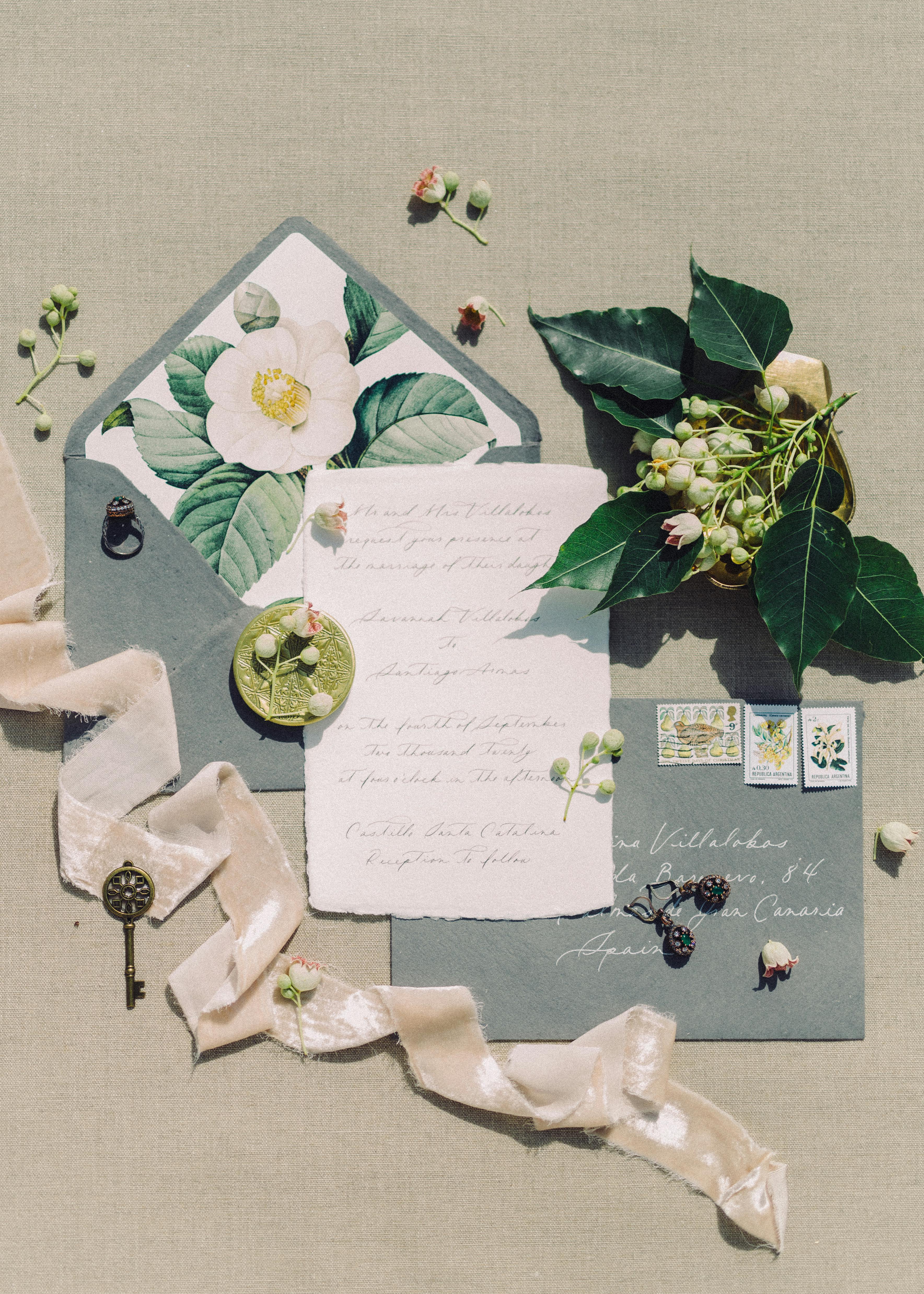 Invitación, anillo, llave y flores