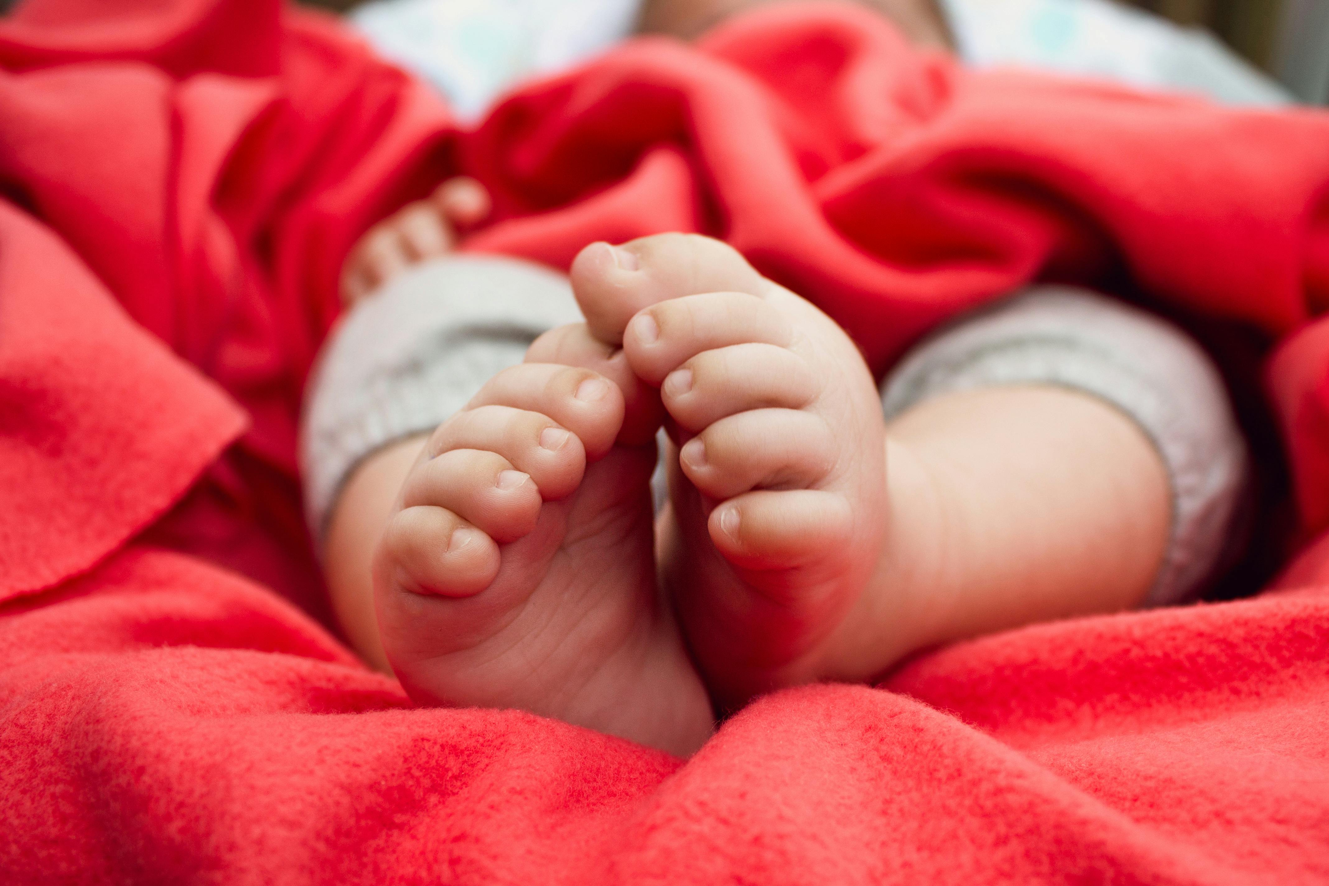 Bebé durmiendo con una manta roja