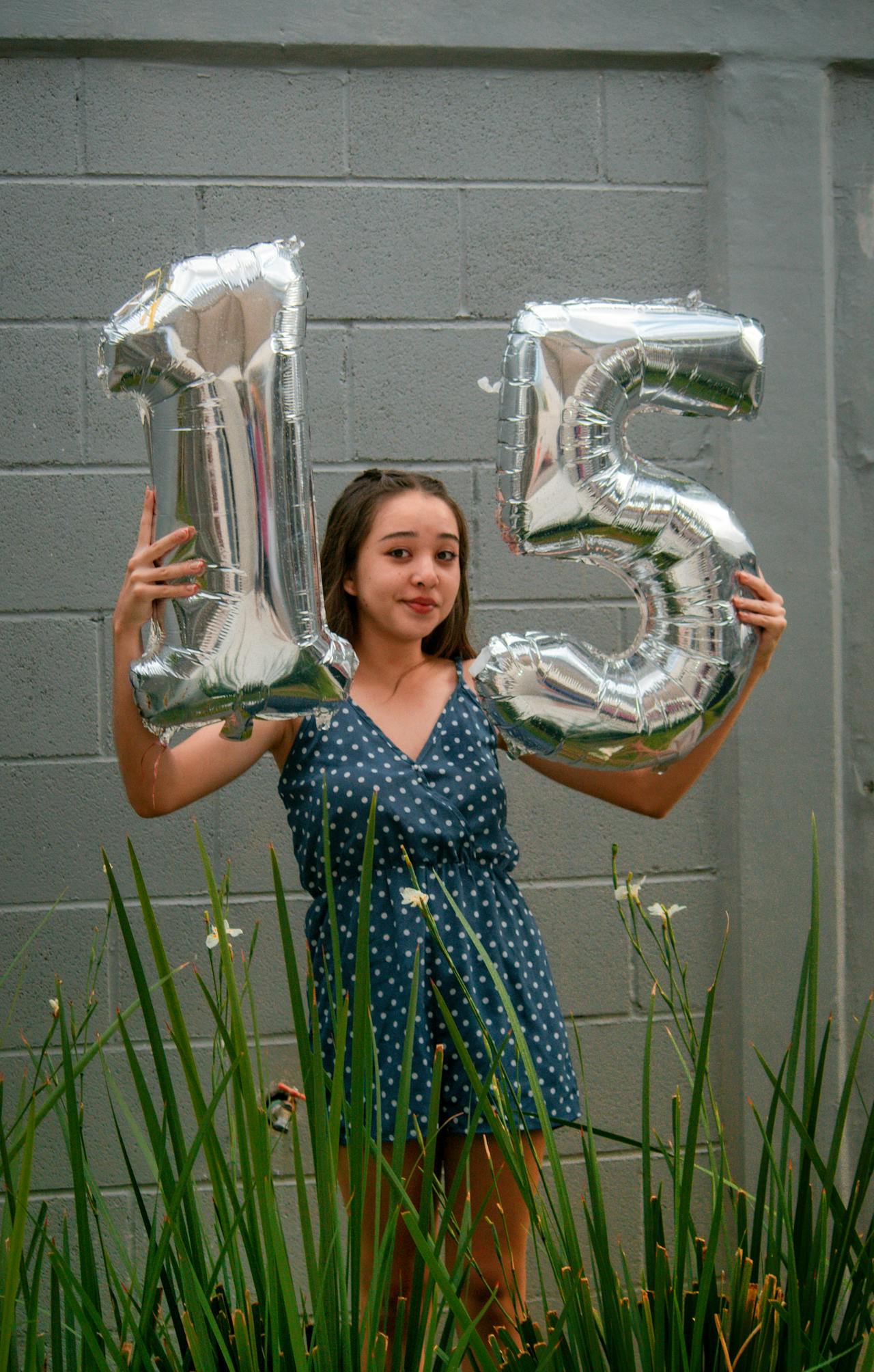 Quinceañera estirada con globos blancos